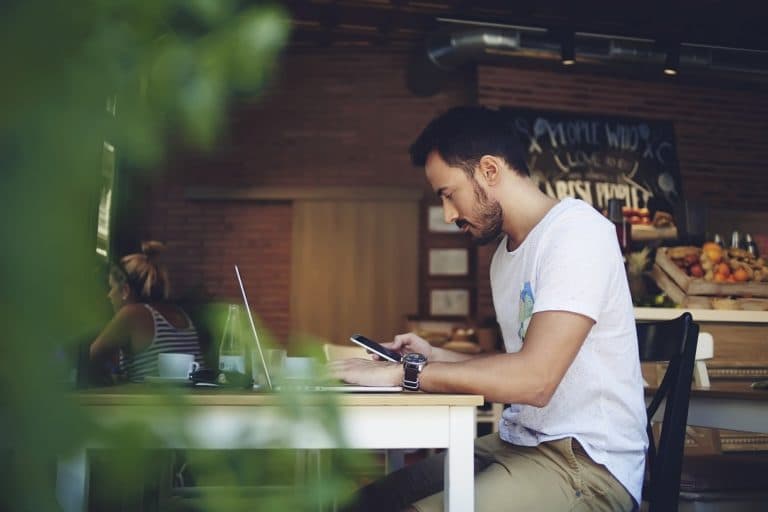 Person using a phone in a cafe to join a venue experience.